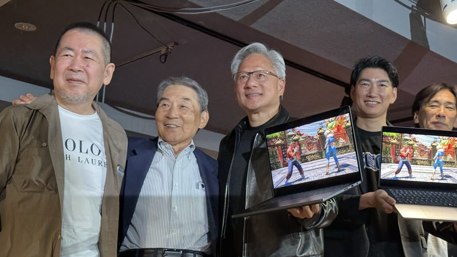 Nvidia CEO Jensen Huang with Sega executives holding laptops running Virtua Fighter